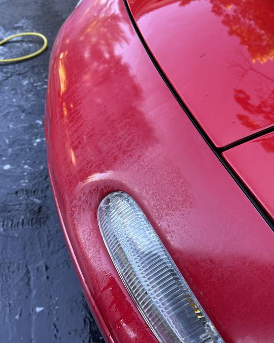 Mazda Miata bumper before paint correction, heavily oxidized