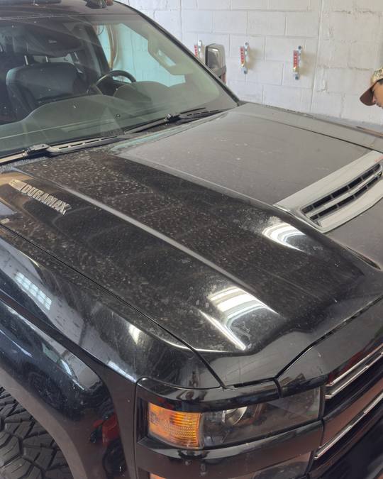 Chevrolet Silverado hood before paint correction, dull with water spots