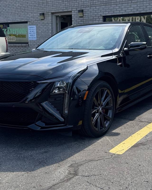 Black Cadillac sedan outside the shop