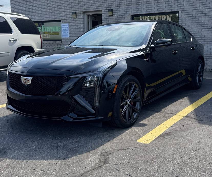 Black Cadillac sedan outside the shop