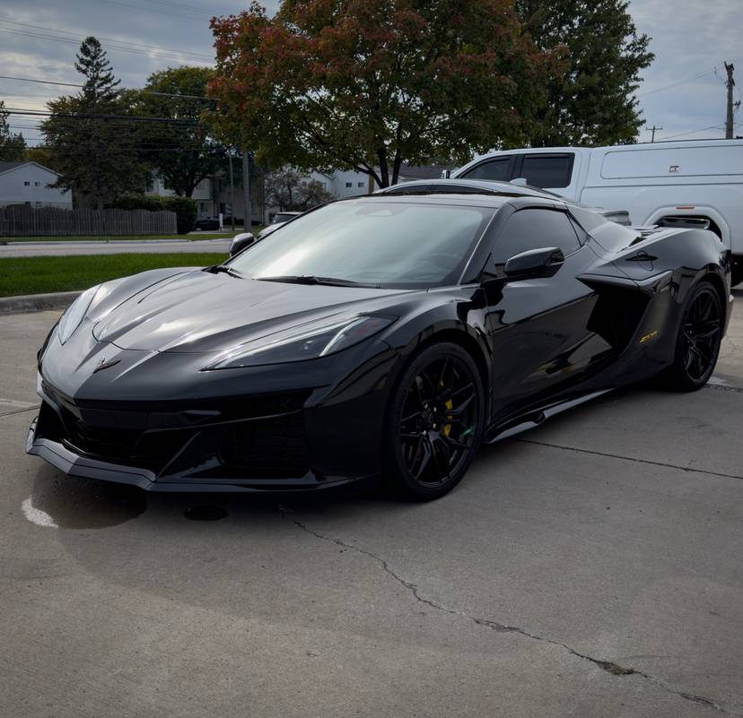 Black mid-engine Corvette with black wheels parked outside