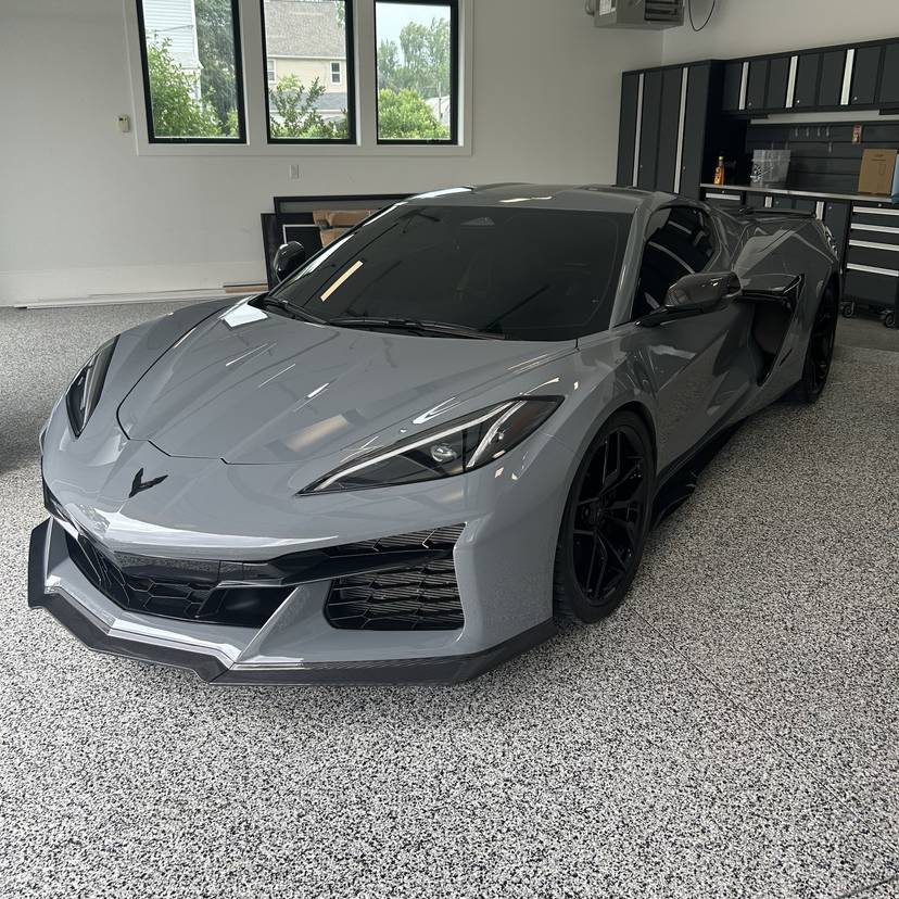 Gray mid-engine Corvette parked on a speckled garage floor