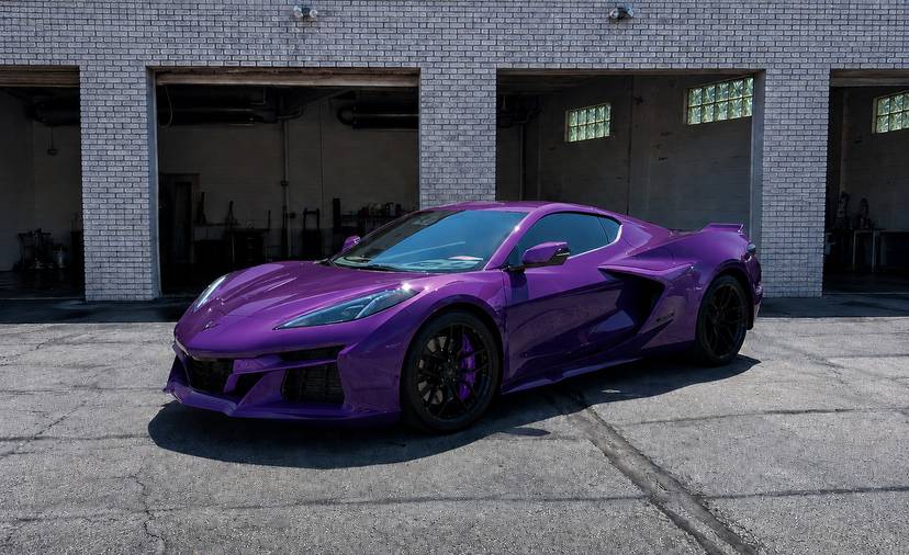Purple Corvette parked in front of the shop bay doors