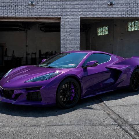 Purple Corvette parked in front of the shop bay doors
