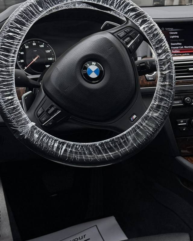Detailed BMW interior with a protective cover on the steering wheel