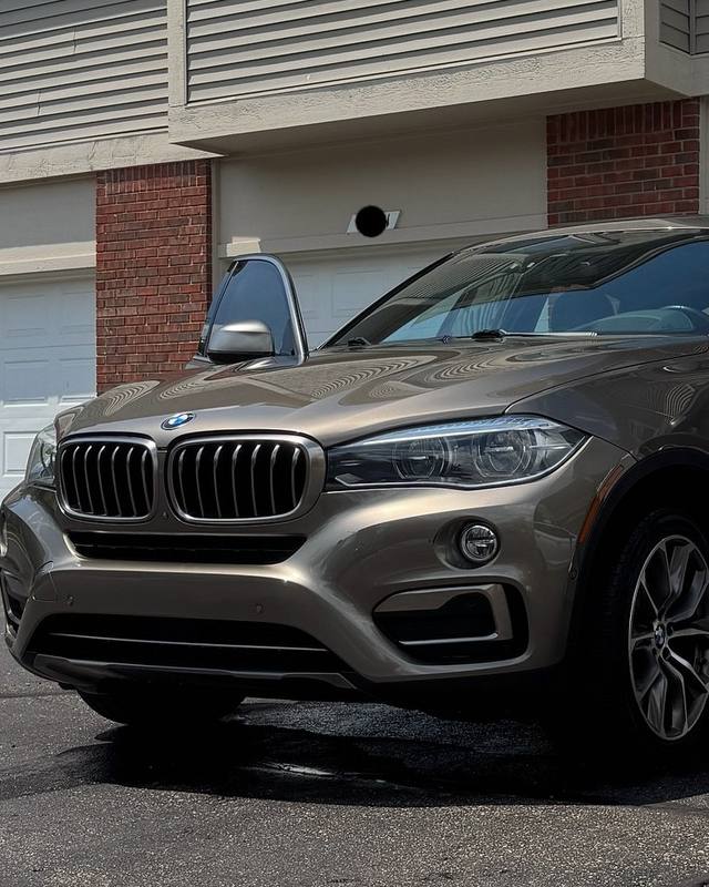 BMW being detailed in a customer’s driveway, doors open