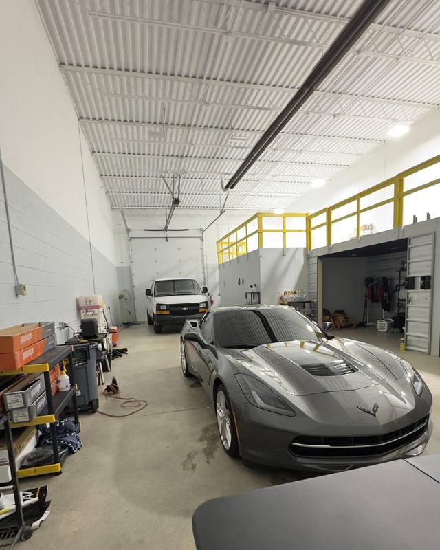 Inside the Refresh My Ride shop with a gray Corvette parked in the bay