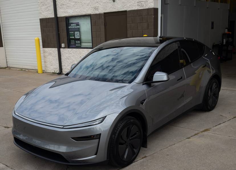 Gray Tesla Model Y outside the shop door
