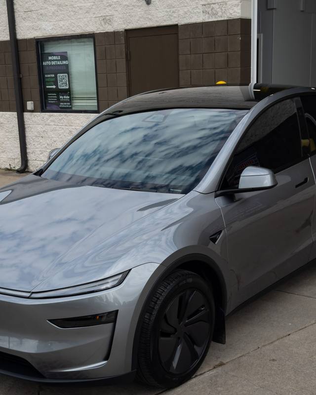 Gray Tesla Model Y outside the shop door
